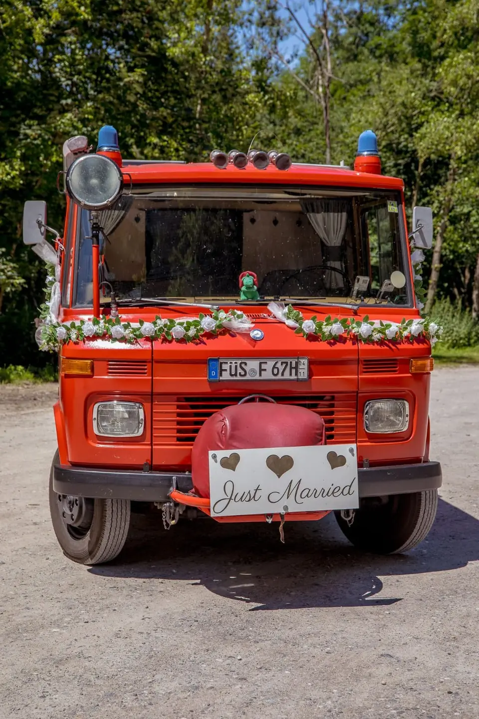 Das Feuerwehrauto mit Blumenschmuck von vorne